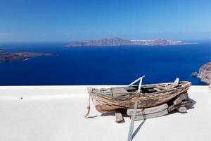 Old boat on the roof of the building on Santorini island, Greece photo