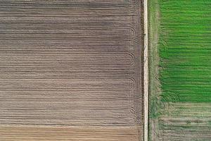 Plowed field and green meadow in flat lay. photo