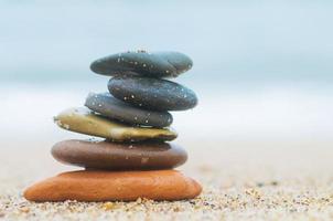 Stack of beach stones on sand photo