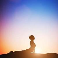 Woman in cobra yoga pose meditating at sunset. Zen photo