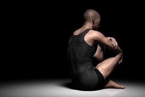 Sad, depressed man sitting alone on floor in dark spotlight. Depression, pain photo