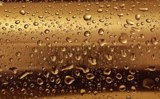 Gold plate with water drops on the rounded surface. photo