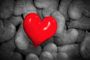 encontrar el concepto de amor. corazones rojos solitarios entre muchos en blanco y negro. foto