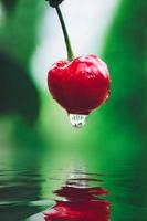 cereza roja con agua cayendo en una piscina foto