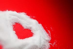 Sweet heart of sugar on red background. photo