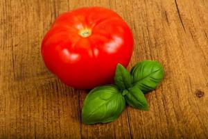 Tomato with basil leaves photo