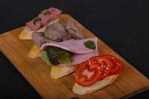 Bruschetta with tomato, ham and tongue photo