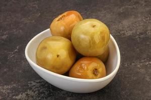 Pickled green tomato in the bowl photo