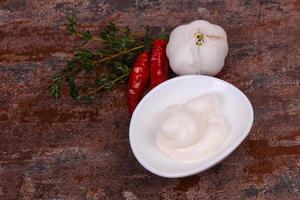 Mayonnaise sauce in the white bowl served thyme and garlic photo
