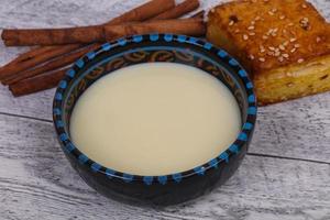 Condenced milk in the bowl with sinnamon and pastry photo