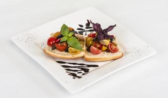 juicy tomatoes on fresh bread, pesto as topping photo