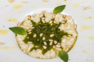 photo of delicious risotto dish with herbs and cedar nut on white background