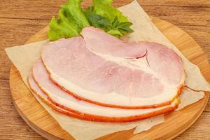 Sliced pork belly over board photo