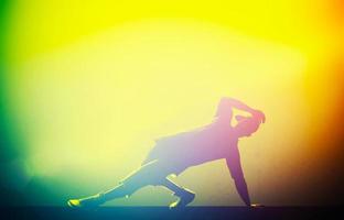 Hip hop, break dance performed by young man in colorful club lights photo
