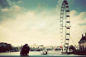 London, England, 2022 - London Eye, UK. A black bird sitting on the bridge over River Thames. Vintage photo