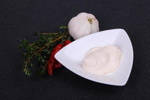 Mayonnaise sauce in the white bowl served thyme and garlic photo