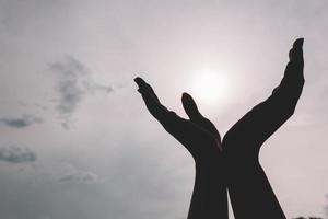 manos levantadas alcanzando el cielo. foto