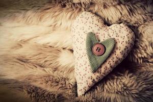 Vintage handmade plush heart on the soft blanket. Romantic love photo