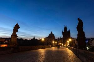 Prague, Czech Republic, 2022 - Charles Bridge at sunrise, Prague, Czech Republic. Dramatic statues and medieval towers. photo