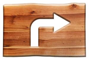 Right turn sign cut in wooden board isolated on white. photo