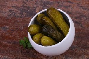 Pickled cucumbers heap in the bowl photo