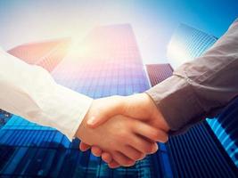 Business handshake, skyscrapers background. Deal, success, cooperation photo