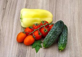 Cucumbers and tomatoes on the branch with yellow pepper photo