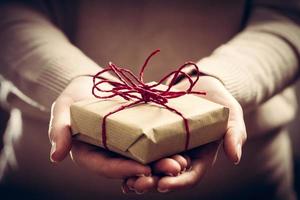 Giving a gift, handmade present wrapped in paper photo