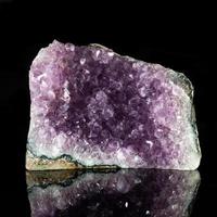 Amethyst rock on black reflective background. photo