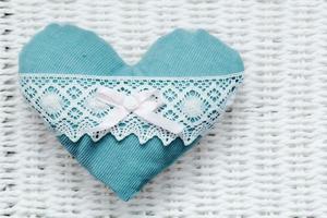 Vintage handmade plush turquoise heart on white rustic wicker photo