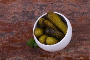 Pickled cucumbers heap in the bowl photo