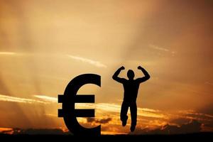 Man jumping for joy next to EURO symbol. Winner photo