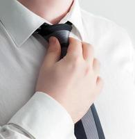 Businessman adjusting his tie, close-up. photo