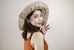 Excited Asian woman in straw hat having beach vacation, isolated over white studio background. photo