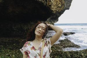 A young beautiful Asian woman flipping her hair at the beach photo