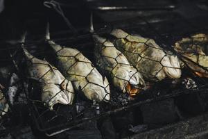 pescado a la parrilla con carbón a la venta en el mercado de comida callejera o en un restaurante en indonesia foto