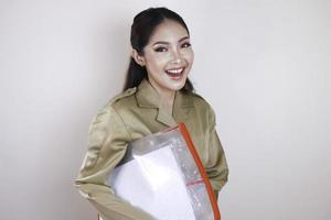 A Young beautiful Asian worker with brown uniform bringing document. Indonesian PNS. photo