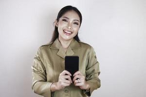 Smiling government worker women holding and pointing screen on smartphone. PNS wearing khaki uniform. photo