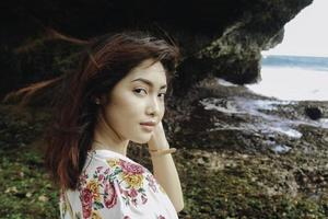 una joven asiática en la playa está mirando a la cámara en gunungkidul, indonesia foto