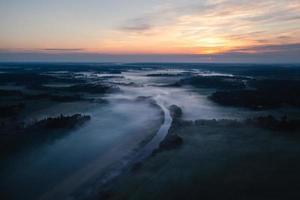 vista aérea de un valle de río brumoso al amanecer foto