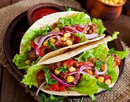 Mexican tacos with meat, vegetables and red onion photo