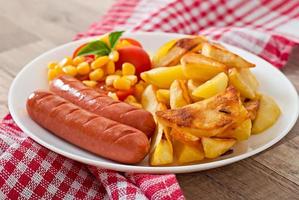 Sausage with fried potatoes and vegetables  on a plate photo