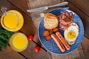 English breakfast - toast, egg, bacon and vegetables in a rustic style on wooden background photo