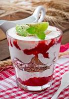 Healthy dessert with muesli and fruit in a glass bowl on the table photo