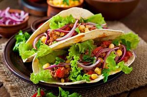 Mexican tacos with meat, vegetables and red onion photo