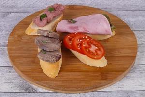 Bruschetta with tomato, ham and tongue photo