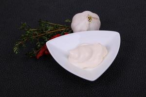 Mayonnaise sauce in the white bowl served thyme and garlic photo