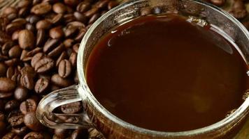 café noir dans une tasse sur fond de grains de café