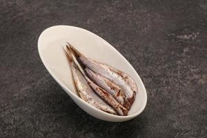 Anchovies in the bowl served basil leaves photo