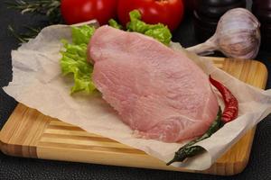 Raw Turkey steak served rosemary photo